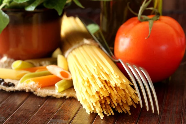 Samenstelling met ruwe pasta's, groenten, olijfolie en kruiden — Stockfoto