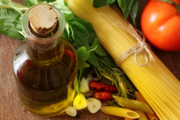 Склад з сирими макаронами, овочами, оливковою олією та травами — стокове фото