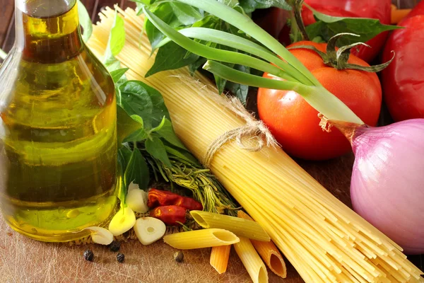 Composição com macarrão cru, legumes, azeite e ervas — Fotografia de Stock