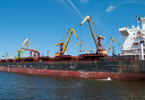 Le gru portuali giganti stanno caricando una nave da carico — Foto Stock