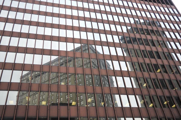 stock image Reflection of building in glass windows of a modern urban building