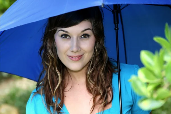 美しい笑顔若いブルネットの女性の青い傘 — ストック写真