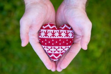 Man hands with red knitted heart clipart