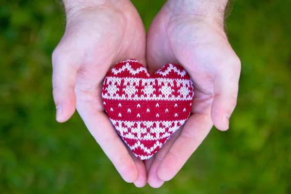 stock image Man hands with red knitted heart