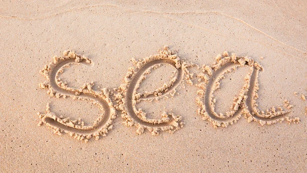 Word "sea" written on beach sand — Stock Photo, Image