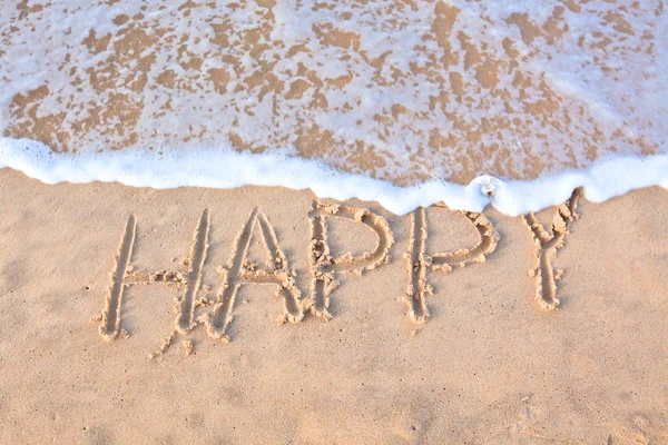 Wort "glücklich" auf Sand am Strand geschrieben — Stockfoto