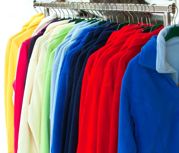 Camisas esportivas multicoloridas penduradas na loja — Fotografia de Stock