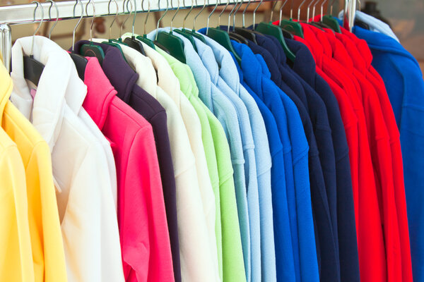 Colourful Textile sport shirts hanging in row at store