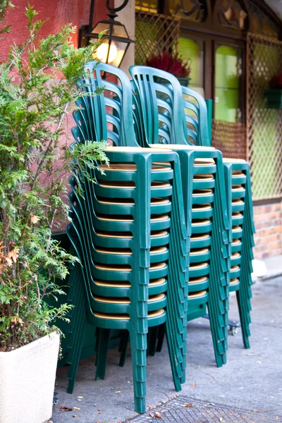 Gestapelte grüne Plastikstühle — Stockfoto