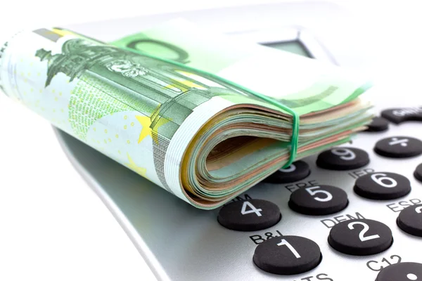 Rolled with rubber euro notes with calculator — Stock Photo, Image