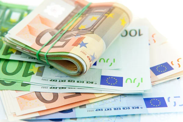 Rouleau avec des billets en euros en caoutchouc sur fond blanc — Photo