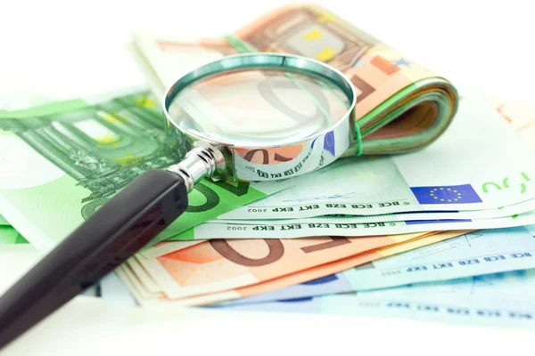 Notas de euro com lupa sobre fundo branco — Fotografia de Stock