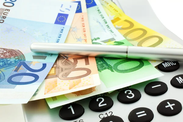 Billetes en euros con calculadora y pluma —  Fotos de Stock