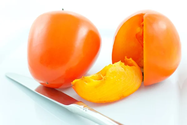 Two ripe persimmons and steel knife — Stock Photo, Image