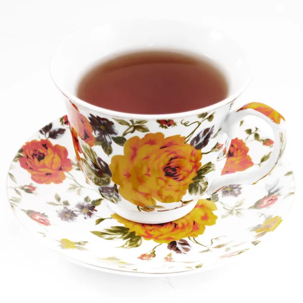 赤とオレンジ色の花を持つ古典的なティーカップ — ストック写真