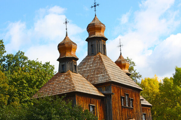 Wooden houses in colored trees taken in park in autumn in Pirogovo museum, Kiev, Ukraine