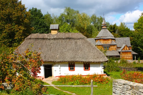 Holzhäuser in farbigen Bäumen im Park im Herbst in pirogovo genommen — Stockfoto