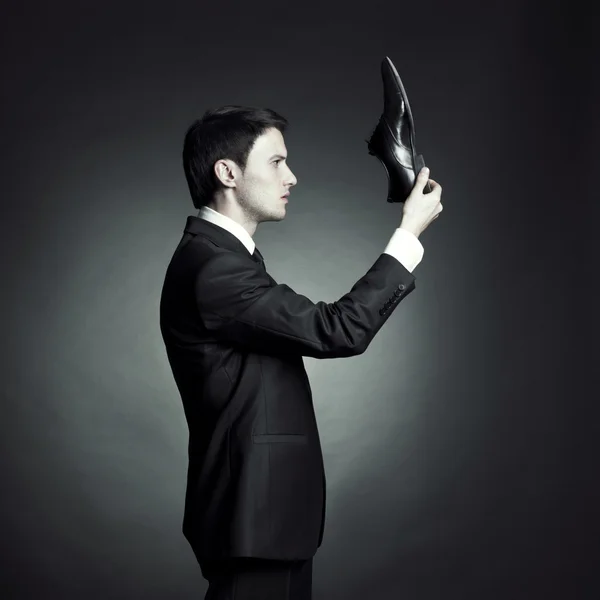 Mann im eleganten Anzug und Schuhen in der Hand — Stockfoto