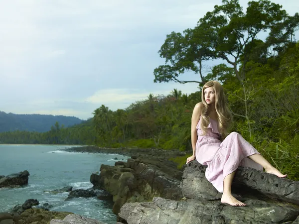 Mooie vrouw op een rotsachtige kust — Stockfoto