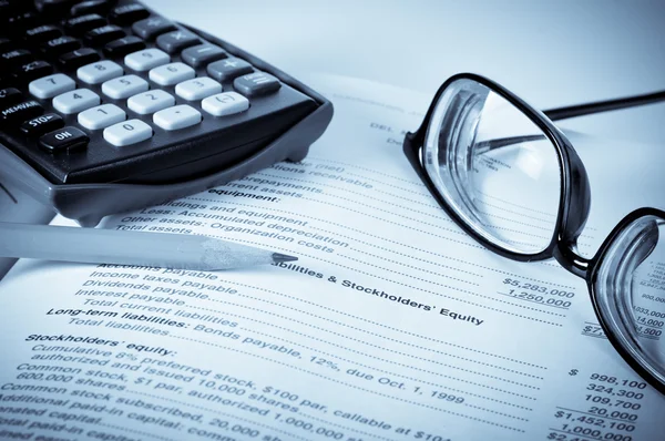 Eye glasses on an accounting book with pencil and calculator — Stock Photo, Image