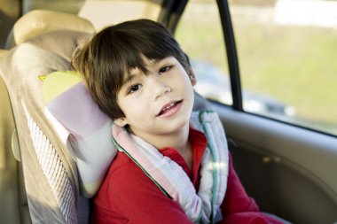 Four year old disabled boy in carseat clipart