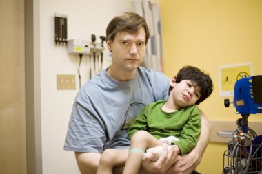 Worried father and child is doctor's office clipart