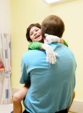 Little boy sitting in doctor's office, laughing clipart