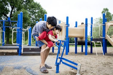 Older brother helping disabled sibling play clipart