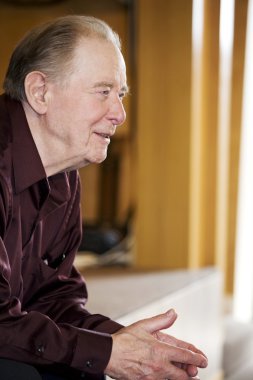 Elderly man sitting in church clipart