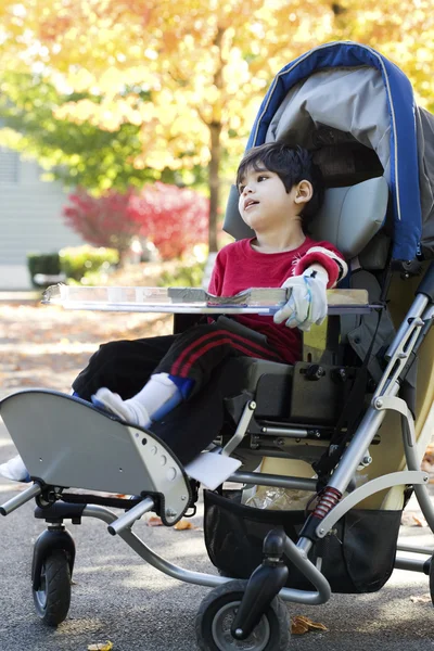 Handicap jongen in medische wandelwagen buitenshuis — Stockfoto