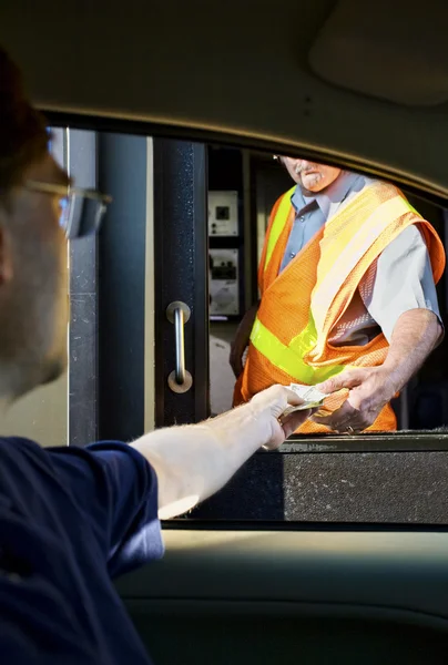 Man paying money at toll booth — Stock Photo, Image