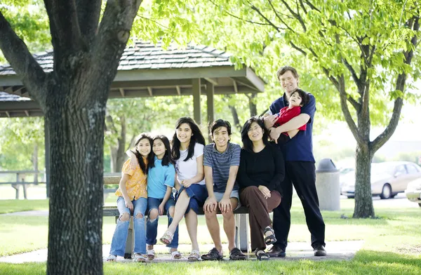 Birlikte açık havada piknik bankta oturan aile — Stok fotoğraf