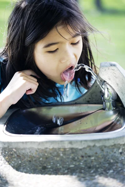 Flickan dricka ur fontänen — Stockfoto