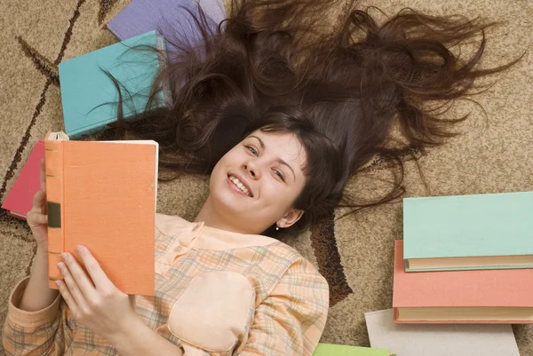 The young girl with books on a light background