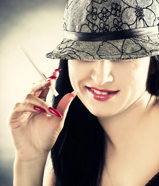 Bonita mulher fumante usando chapéu — Fotografia de Stock
