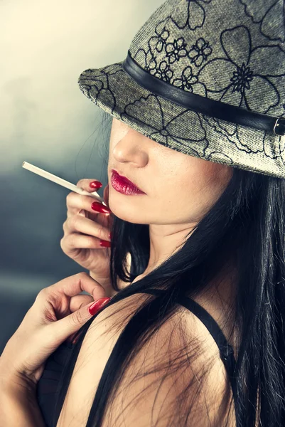 美しい喫煙女性の帽子をかぶっています。 — ストック写真