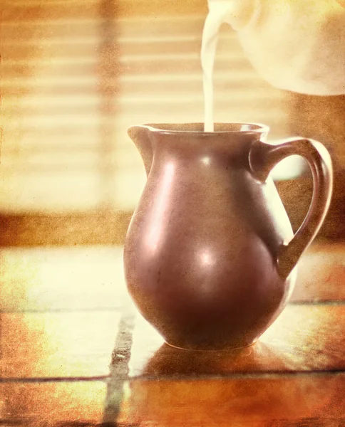 Γάλα που ρίχνει σε μια καφετιά κανάτα — Φωτογραφία Αρχείου