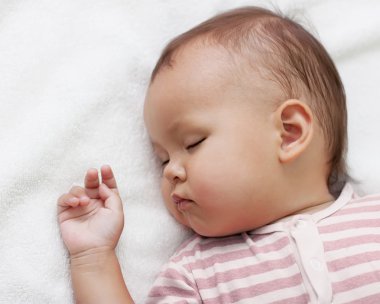 Little girl sleeping on a white towel clipart