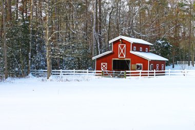 A snow covered Horse barn in a field in the woods covered in snow after a snowstorm with room for your text. clipart