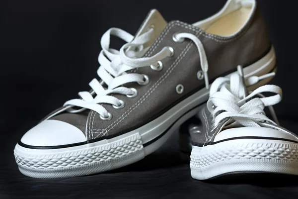 stock image Gray sneakers classic youth footwear at black background
