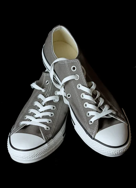 Zapatillas de deporte grises calzado juvenil clásico en fondo negro — Foto de Stock