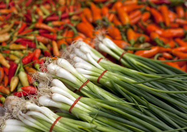 Trh s čerstvými chilis a jarní cibulkou — Stock fotografie