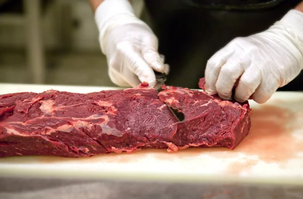 肉屋は肉を切る — ストック写真