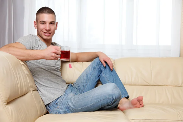 Νεαρός Άνδρας Κάθεται Στο Σπίτι Και Πίνοντας Τσάι — Φωτογραφία Αρχείου
