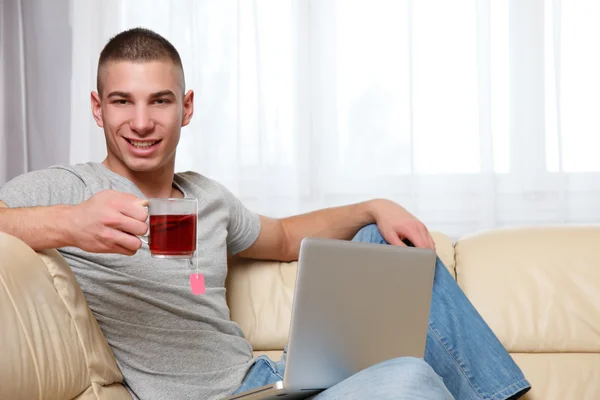 Νεαρός Άνδρας Κάθεται Στο Σπίτι Και Πίνοντας Ένα Φλιτζάνι Του — Φωτογραφία Αρχείου