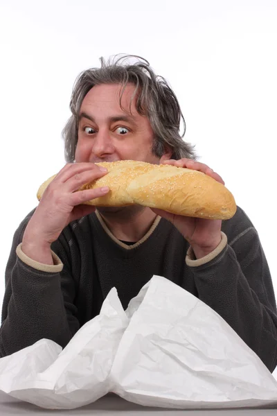 年轻男子吃大面包 — 图库照片