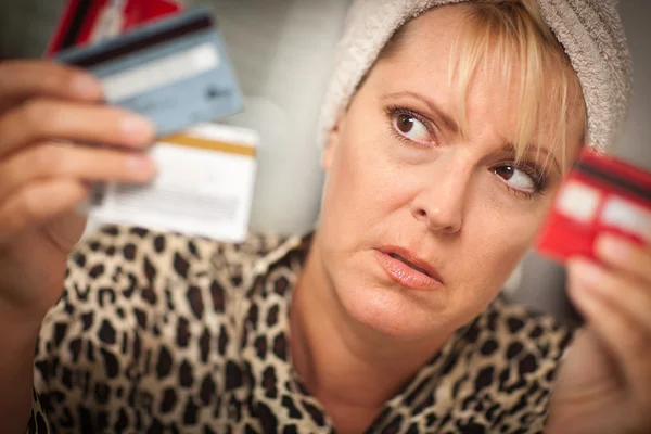 Mulher estressada olhando para seus muitos cartões de crédito — Fotografia de Stock