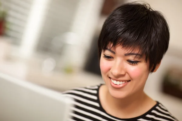 Sourire femme multiethnique en utilisant un ordinateur portable — Photo