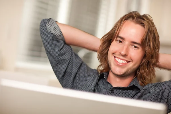 Szczęśliwy młody człowiek przy użyciu komputera przenośnego — Zdjęcie stockowe