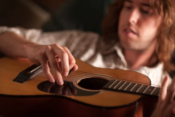 Jonge muzikant speelt zijn akoestische gitaar — Stockfoto